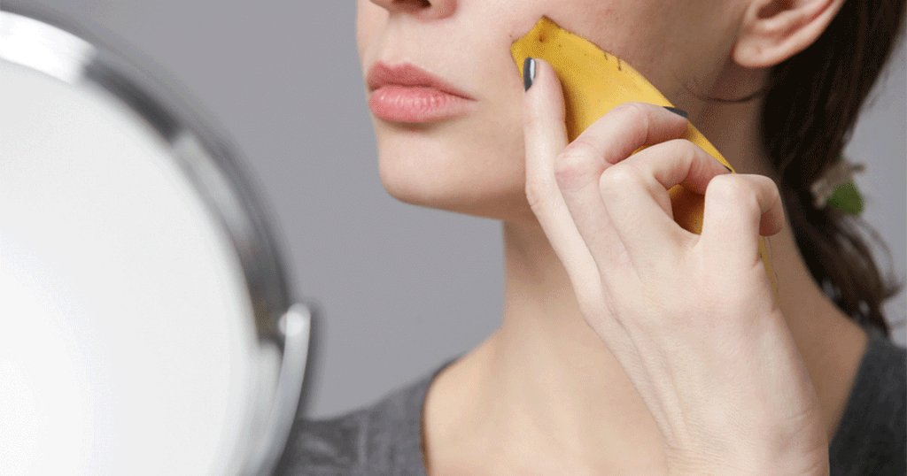 سيدة تفرك وجهها بقشر الموز