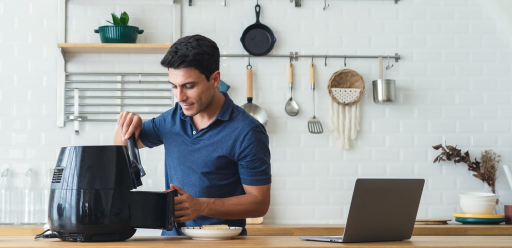 رجل يحضر الطعام بالقلاية الهوائية