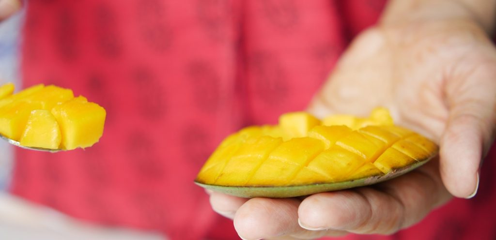 سيدة تتناول مانجو طازجة
