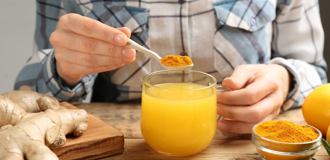 امرأة تضيف الكركم الى مشروب البرتقال