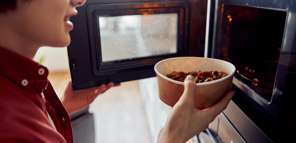 تسخين الطعام في وعاء كرتوني في الميكروويف
