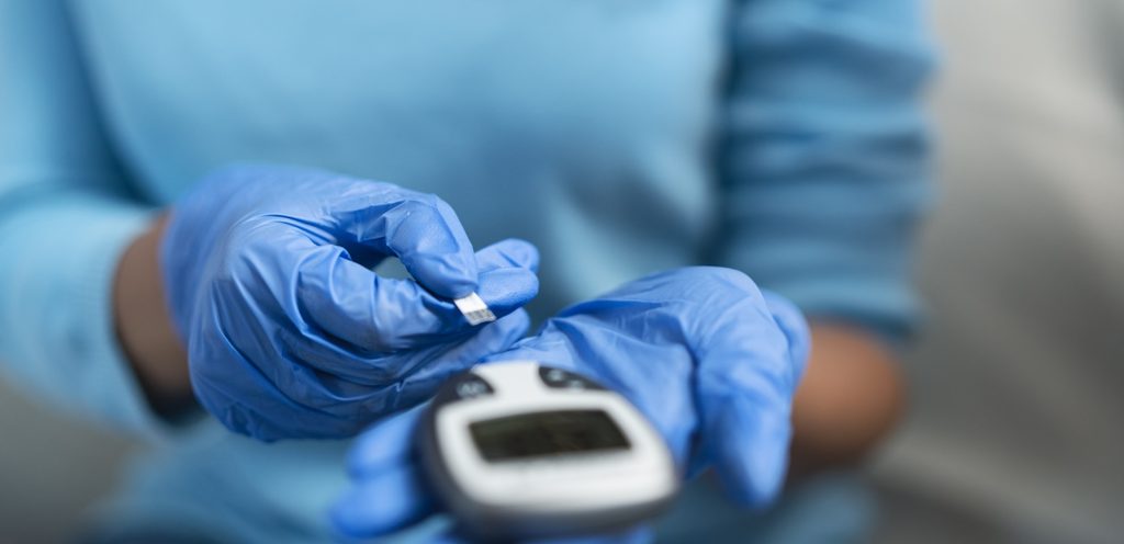 ممرضة مع جهاز قياس السكر